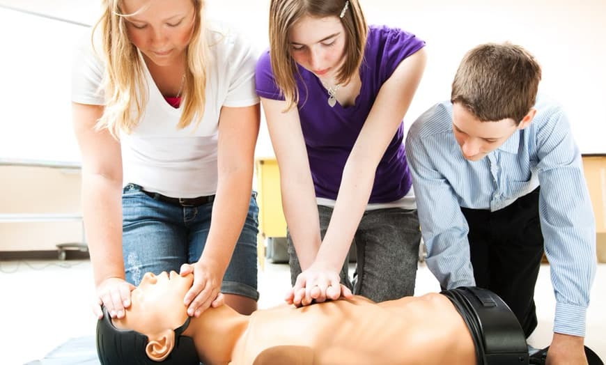 Learners practicing CPR together on a training manikin