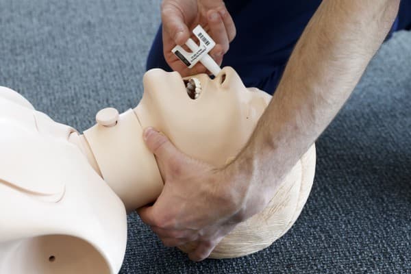 Demonstrating a nasal naloxone device on a training manikin